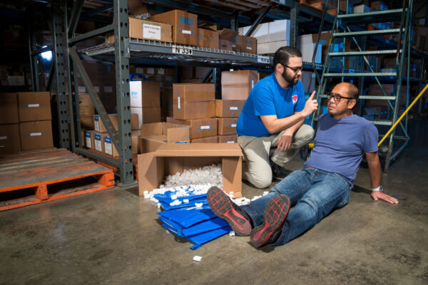 two men dealing with an emergency in the workplace