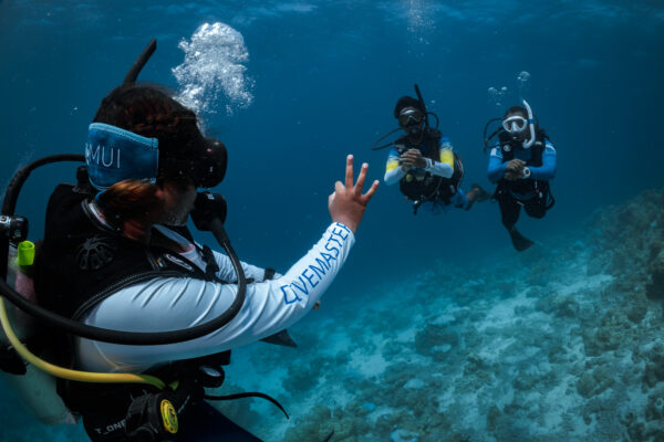 PADI Pro signaling underwater to check on students