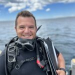 Pato Cartelli, winner of the Torchbearer award, is next to the sea dressed in scuba diving gear