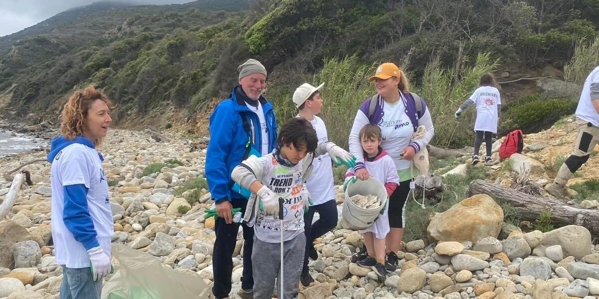 A group of adults and children clean up the coast in Italy