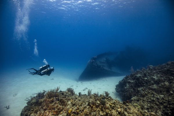 Image of diver buddies near a wreck in clear waters in the Caribbean