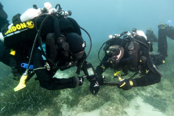 two technical divers dive on rebreathers underwater