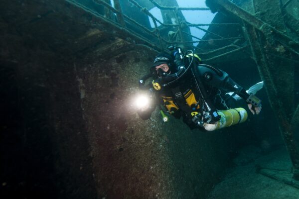 a rebreather diver explores a shipwreck