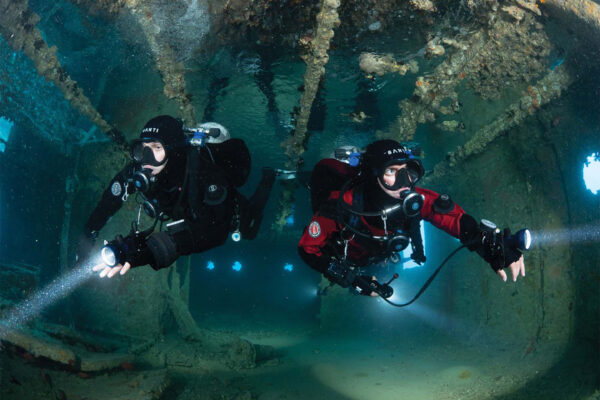 two divers with double tanks on their backs