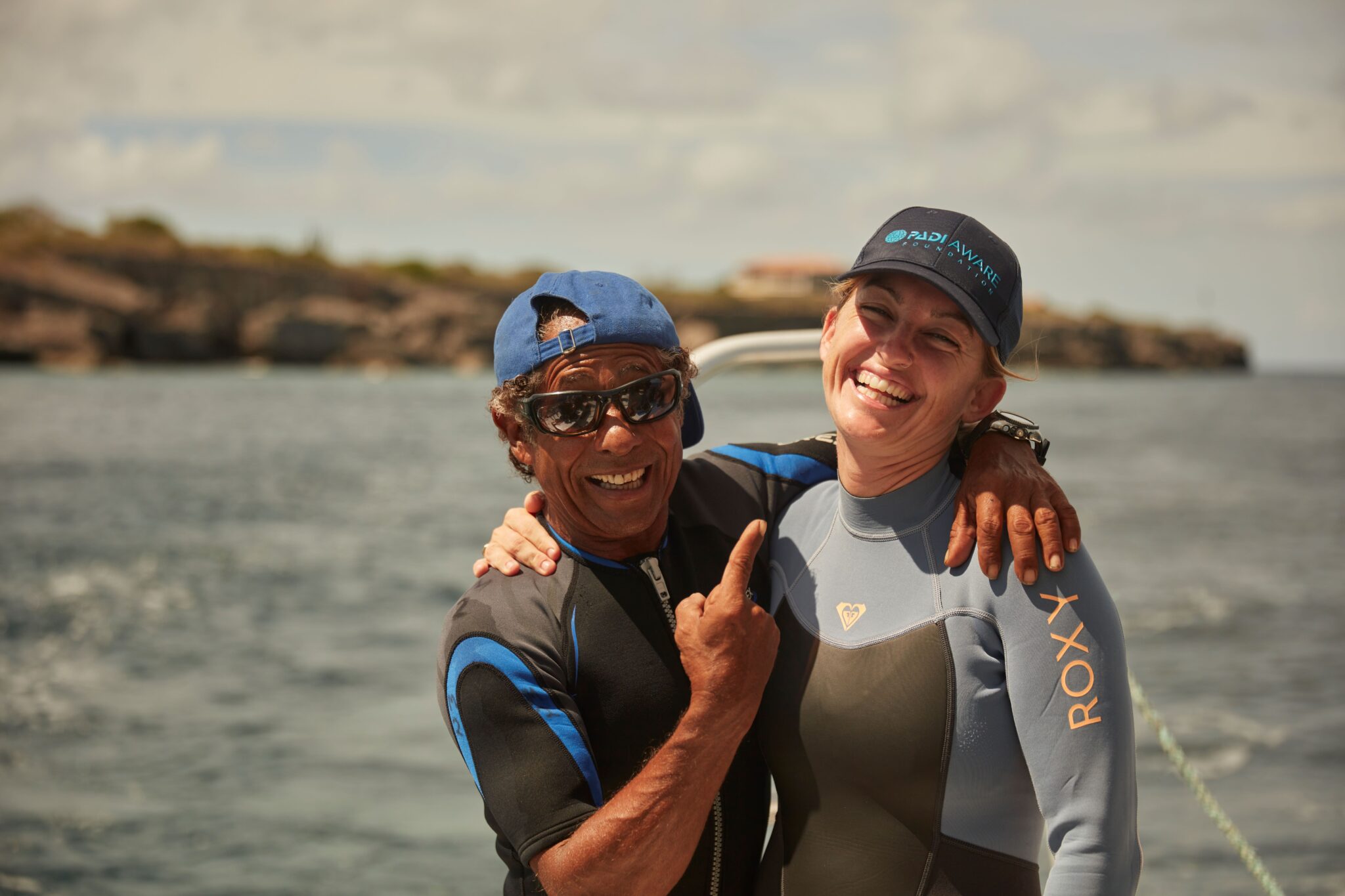 two divers hug each other and smile
