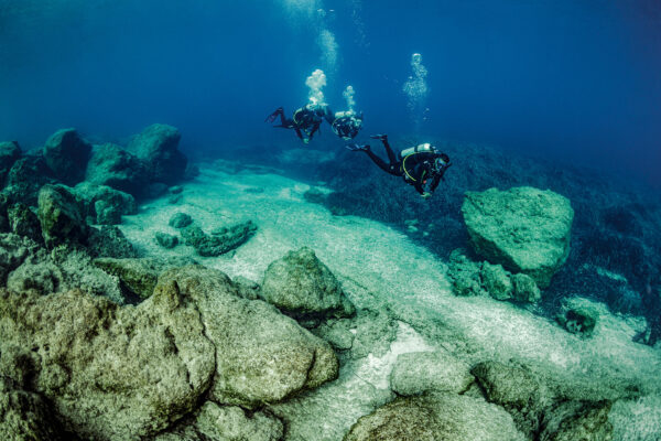 three divers explore the underwater world in Greece