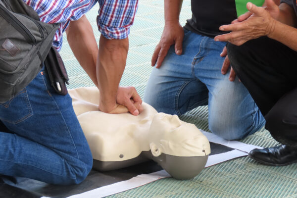 Group practicing CPR on dummy