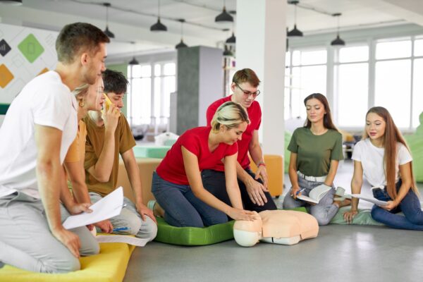 Group practicing CPR on mannequin - Emergency First Response