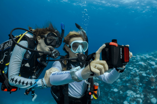 two divers make a selfie underwater with a sealife camera