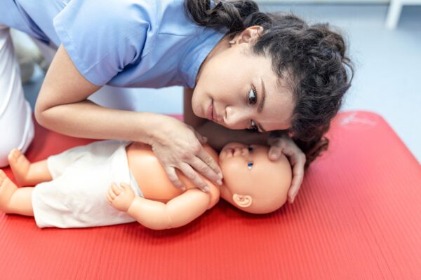 A girl practices infant cpr on a dummy