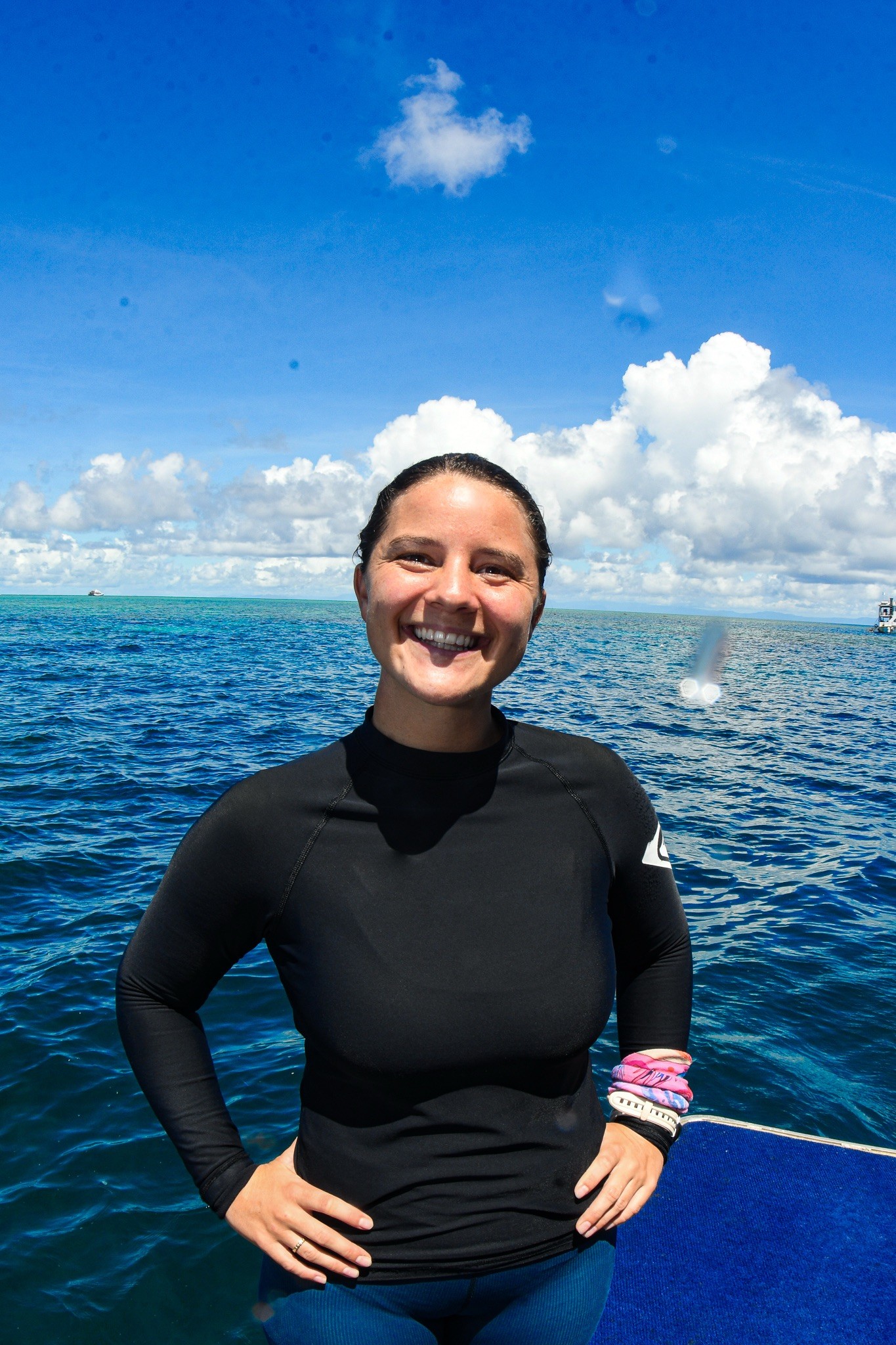 PADI OWSI Sidney standing in her wetsuit in front of the ocean in Australia