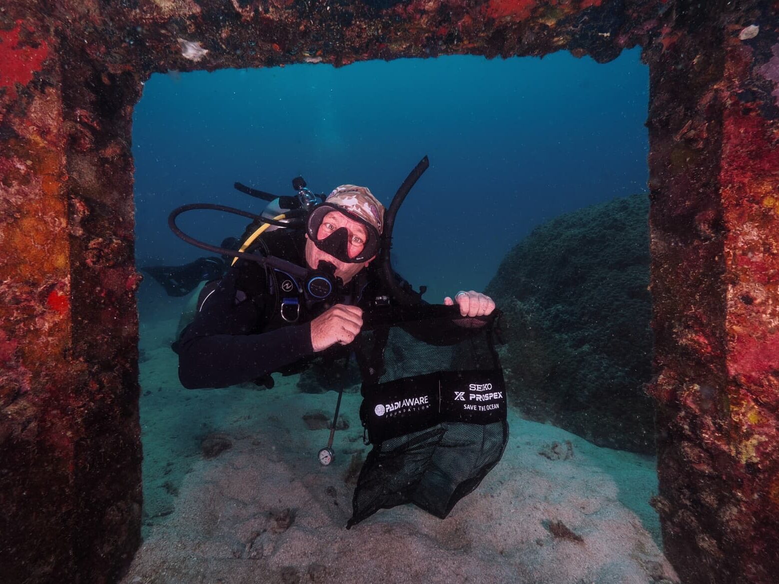 Дайвер демонстрирует пакет Dive Against Debris во время очистительного погружения на Кох Тао