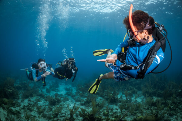 a PADI Instructor checks the air level of his students underwater