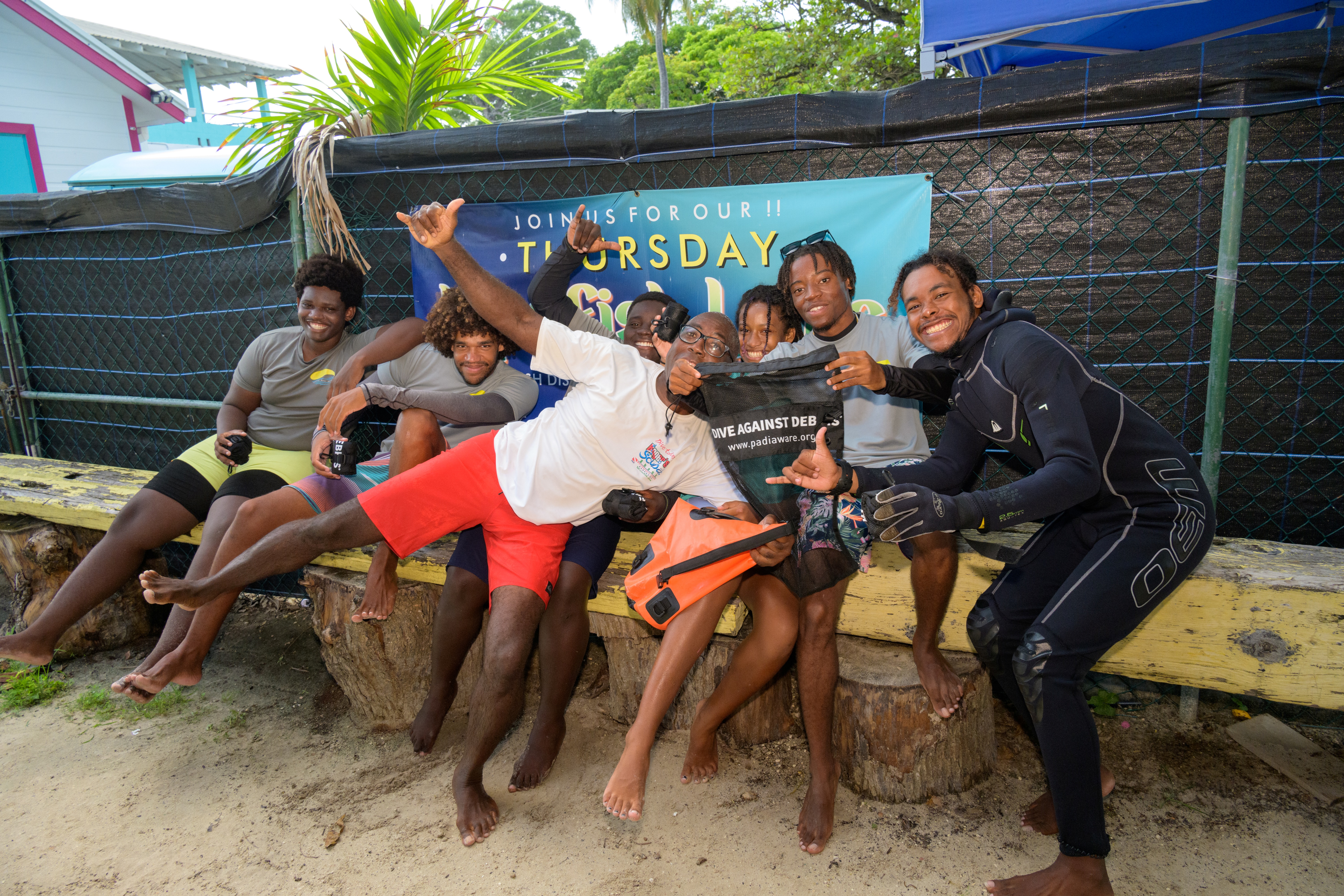 Foto de grupo de PADI Torchbearers posando con una bolsa Dive Against Debris.