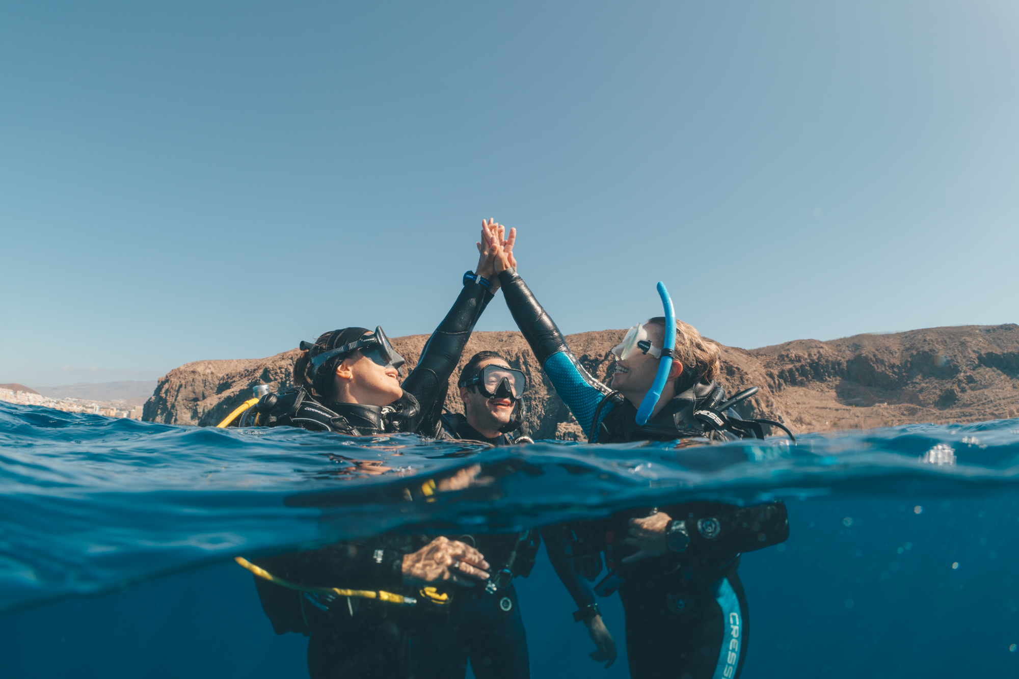 Two divers high five after a dive in the Canary Islands