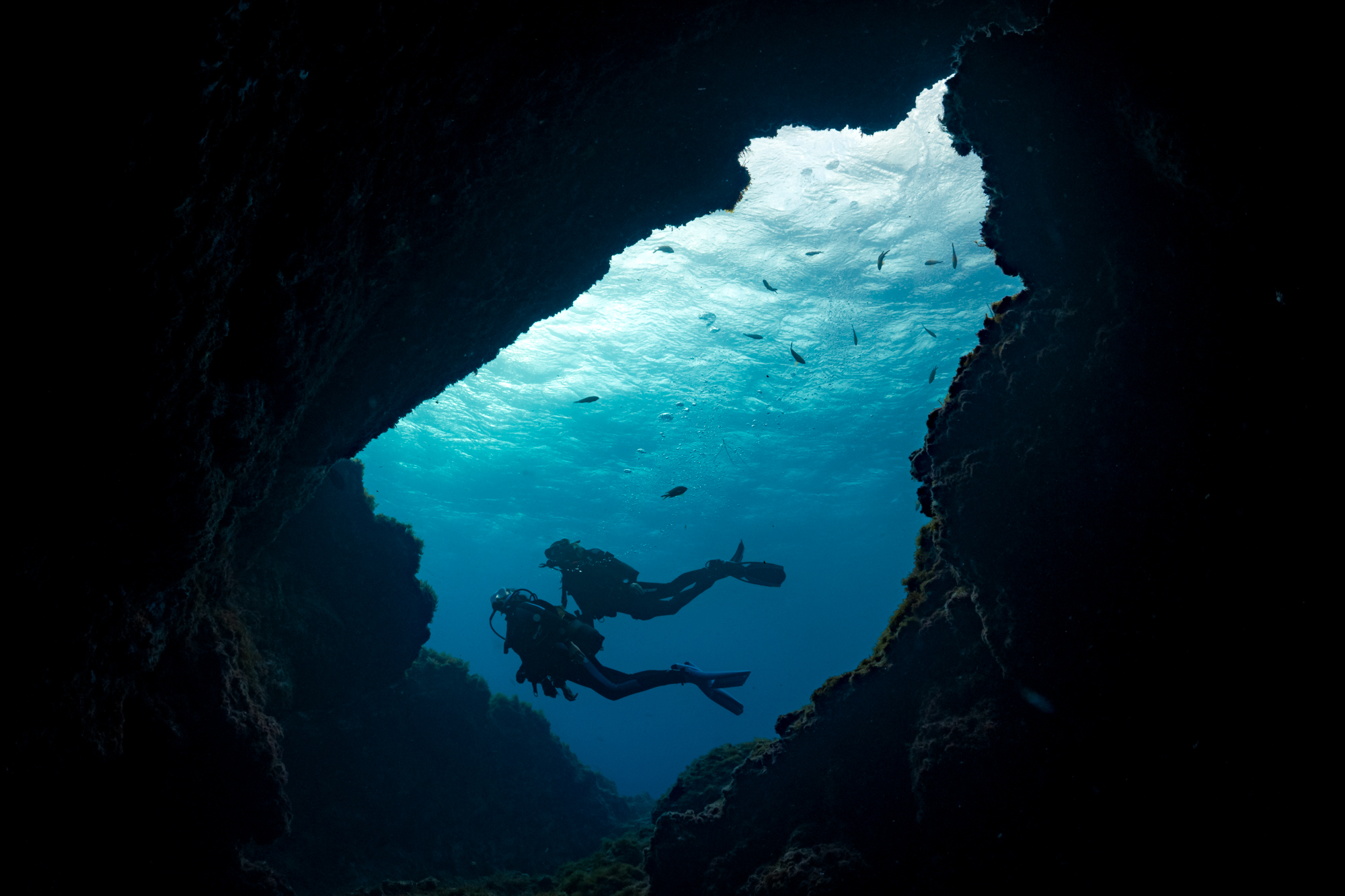 Two divers pass a cave underwater in Spain